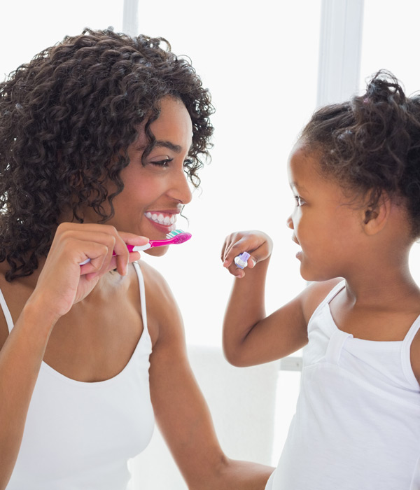 mom and daughter brushing their teeth