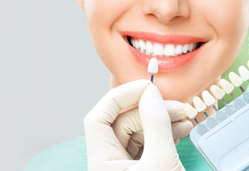 A Smiling woman examining results after Teeth Whitening treatment in Brookfield, WI
