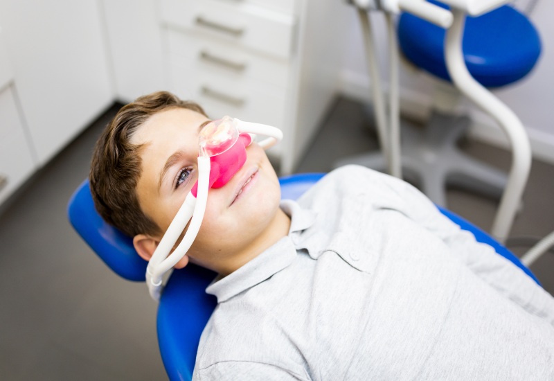 A child in a chair wearing a nasal mask shows how sedation dentistry is safe for kids in Brookfield