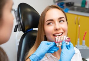 A dental professional guides a patient using a shade guide for Dental Veneers in Brookfield, WI