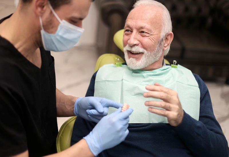 A dentist discussing custom dentures with an elderly patient in Brookfield, WI